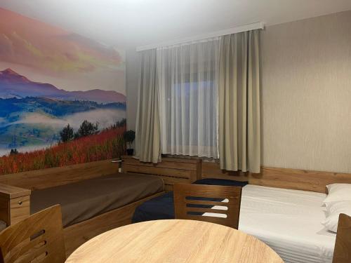 a hotel room with two beds and a painting on the wall at Star Apartments Konaci in Kopaonik