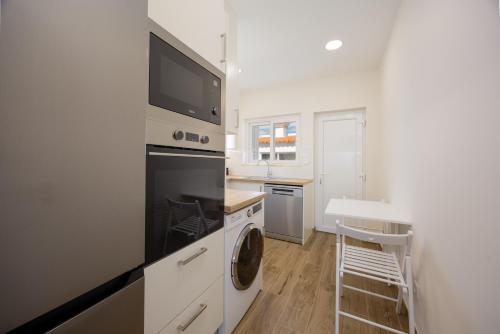 a white kitchen with a washer and dryer in it at Pontalaia Atlantic View in Sagres
