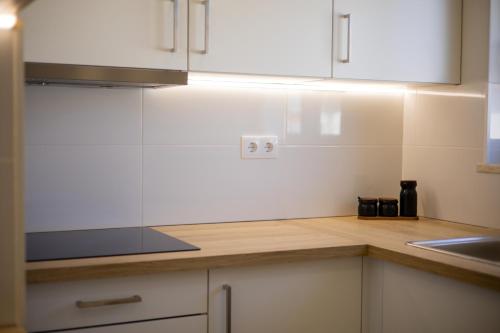 a kitchen with white cabinets and a sink at Pontalaia Atlantic View in Sagres
