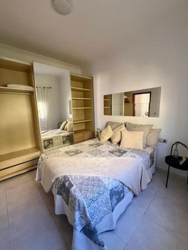 a bedroom with a large bed and a large mirror at Casa Oreo in Tarajalejo