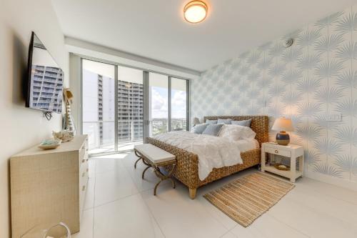Un dormitorio con cama, escritorio y ventanas en Ocean Views and Pool Access Riviera Beach Condo!, en Riviera Beach