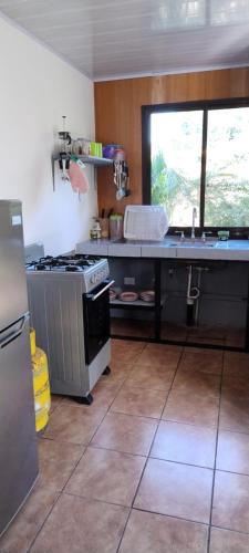 a kitchen with a stove and a counter top at Cabinas Los Tucanes in Cahuita