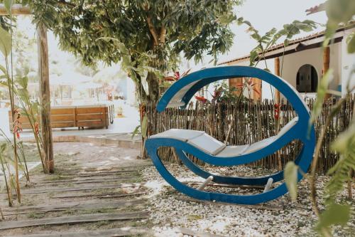 a blue bench sitting next to a fence at Pousada o Casarão in São Miguel dos Milagres