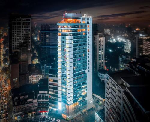 a lit up building in a city at night at Crowne Plaza Dhaka Gulshan by IHG in Dhaka