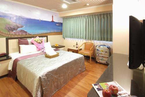 a hotel room with a bed and a tv at Left Bank Hotel in Hsinchu City
