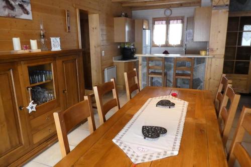 une salle à manger avec une table et une cuisine dans l'établissement Chalet Crocus - Magnifique chalet aux pieds des pistes au cœur de la station de Réallon 10 à 12 couchages CHALCROCUS MAE-9031, à Réallon