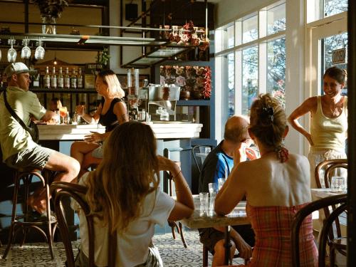 a group of people sitting at a table in a restaurant at Blue Marlin Dive Boutique Hotel in Kuta Lombok