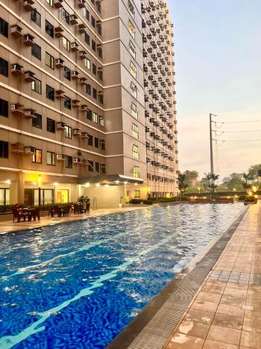 a large swimming pool in front of a building at SMDC Green 2 Staycation, The Traditional & Modern Fusion Condo in Pasong Bayog