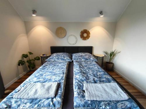 a bedroom with a large bed with blue sheets at Dom nad jeziorem WIDOKówka in Żywiec