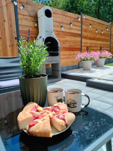 a table with a plate of bread and cups of coffee at Dom nad jeziorem WIDOKówka in Żywiec