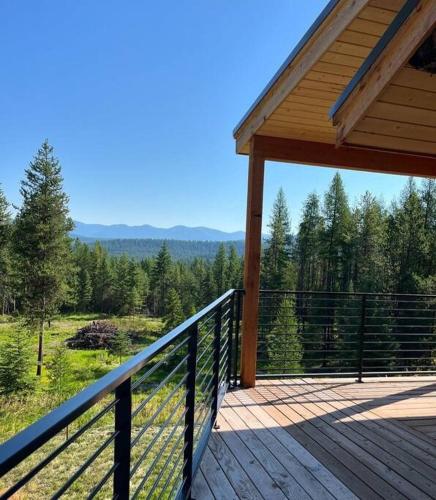 a porch of a house with a view of a forest at Cabin on 15 acres with Mtn view, firepit, Starlink in Whitefish