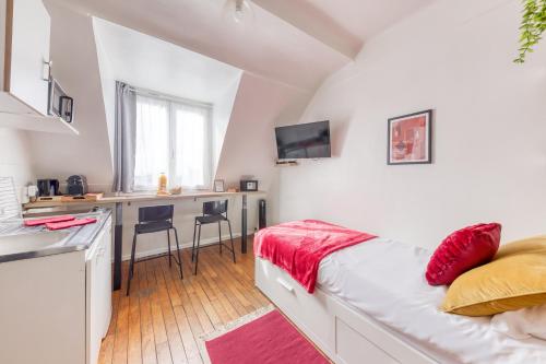Cet appartement comprend une chambre avec un lit et une cuisine avec un comptoir. dans l'établissement Le Burgundy - Cosyloc Agency - Centre historique, à Vincennes