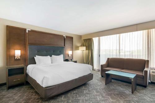 a hotel room with a bed and a couch at Best Western Plus Kansas City Sports Complex Hotel in Kansas City