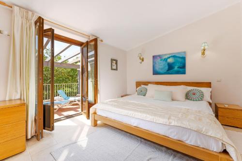 a bedroom with a large bed and a balcony at The Quinta Bio Pool, Swimming Pool, 3 Bedroom ensuites Villa in Almancil