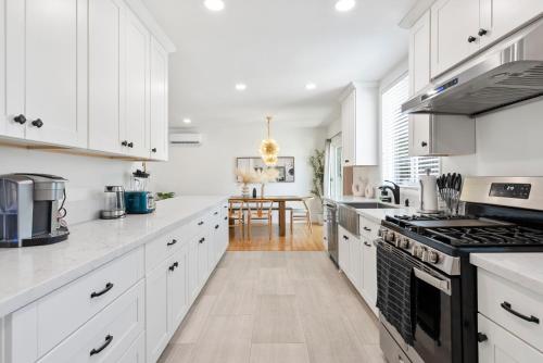 a kitchen with white cabinets and a stove top oven at Spacious 3BR Home Near Disneyland & Knotts Berry Farm in Fullerton