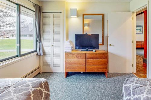 a bedroom with a tv on a wooden dresser at Village Green Unit 1A in Stowe
