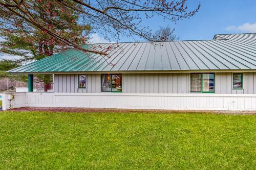 a white house with a green roof at Village Green Unit 1A in Stowe