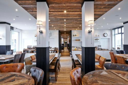 a dining room with wooden tables and chairs at West Bay in Middelkerke