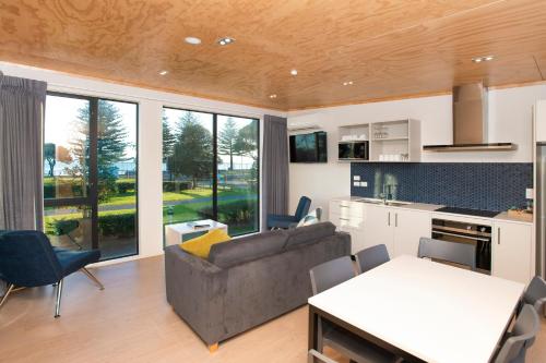 a living room with a couch and a kitchen at Waikanae Beach Ocean View Apartments in Gisborne