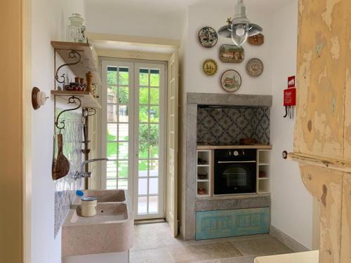 a kitchen with a fireplace and a sink in a room at Entire House - Romantic Vintage Cottage in Sintra