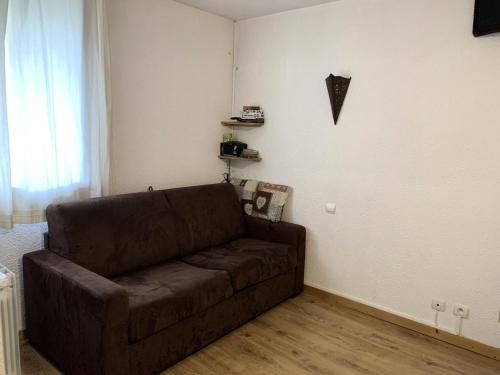 - un salon doté d'un canapé brun dans l'établissement Résidence Armoise - Studio de 18m2 pour 2 personnes avec petite veranda MAE-5924, aux Menuires