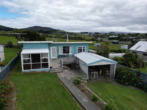 a small blue house with a porch and a yard at Beach Bliss Retreat in Riverton