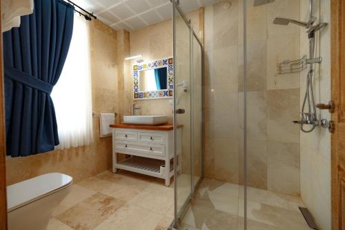 a bathroom with a glass shower and a sink at Cappadocia Villa Comfort in Nevsehir