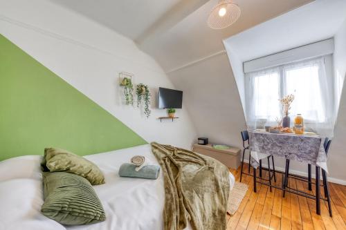 a bedroom with a bed with a green and white wall at Le Végétal - Cosyloc Agency - Centre historique in Vincennes