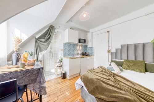 une chambre avec un lit et une table et une cuisine dans l'établissement Le Végétal - Cosyloc Agency - Centre historique, à Vincennes