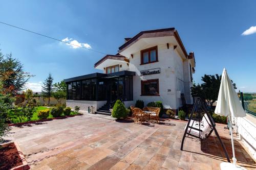 a house with a patio and an umbrella at Cappadocia Villa Comfort in Nevsehir