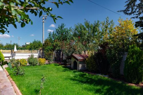 a yard with a dog house in the grass at Cappadocia Villa Comfort in Nevsehir