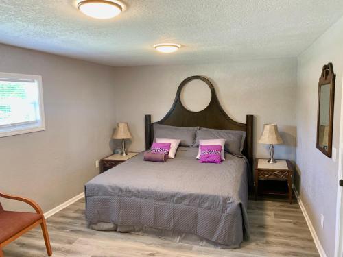 a bedroom with a bed with two pink pillows at Getaway Clubhouse in Winter Haven