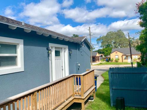 ein blaues Haus mit einer Holzterrasse im Hof in der Unterkunft Getaway Clubhouse in Winter Haven