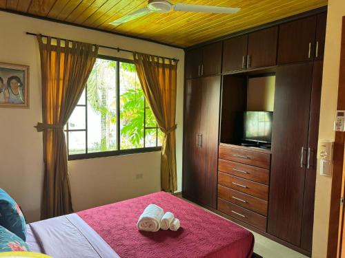 a bedroom with a bed and a tv and a window at La CASA DE LA ABUELA in Sucúa