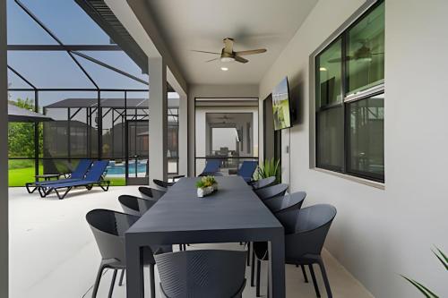 a dining room with a black table and chairs at Paradiso Grande Luxury w/ Cinema, Games & Pool in Orlando