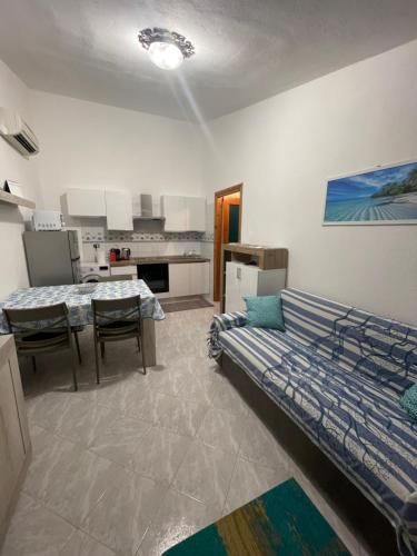 a living room with a couch and a kitchen at Valehome Villasimius in Villasimius
