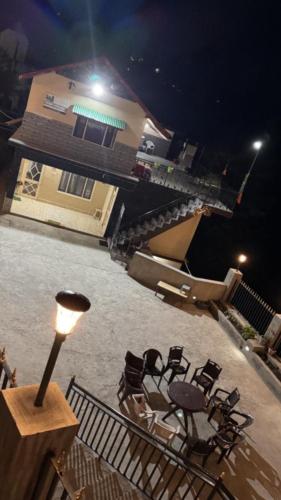 a group of chairs and a table on a balcony at night at Aditya Homestay Dalhousie in Dalhousie