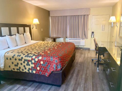 a hotel room with a bed and a desk at Super 8 by Wyndham Albuquerque Downtown in Albuquerque