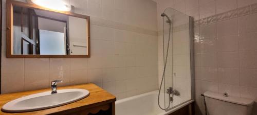 une salle de bain avec un lavabo et une douche avec un miroir dans l'établissement Résidence Le France - Studio 3 personnes Plagne Centre MAE-4884, à La Plagne Tarentaise
