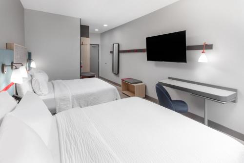 a hotel room with two beds and a flat screen tv at avid hotel North Platte by IHG in North Platte