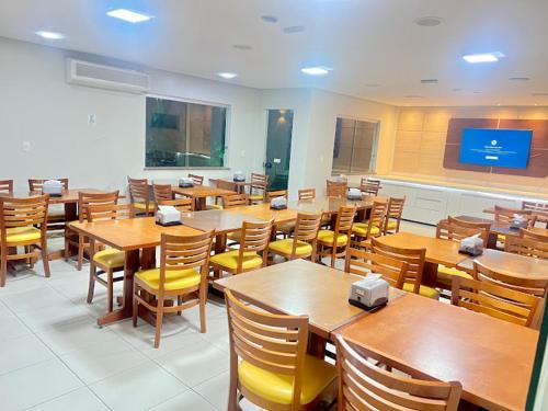 a dining room with wooden tables and chairs at Pousada Piu Bella in Jequié