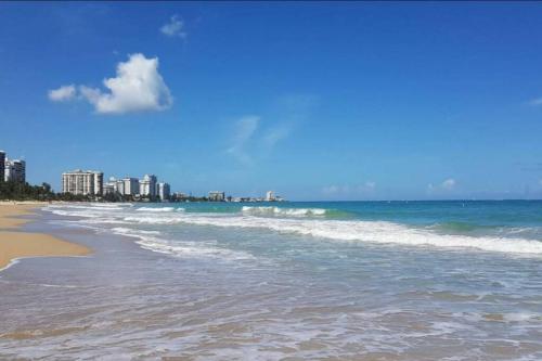 Blick auf den Strand mit Gebäuden im Hintergrund in der Unterkunft Cocomar in San Juan