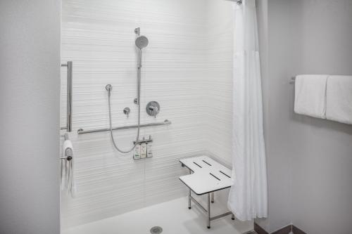 a bathroom with a shower and a bench in it at avid hotel North Platte by IHG in North Platte
