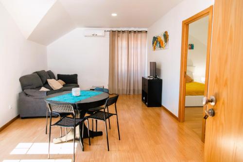 Una sala de estar con una mesa y sillas y un sofá. en Arcadas da Vila, en Manteigas