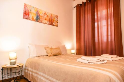 Un dormitorio con una cama con dos lámparas y una ventana. en Arcadas da Vila, en Manteigas