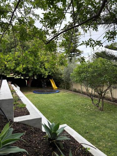 a backyard with a playground with a slide at Versatile summer beach house or cosy winter retreat! in Mandurah