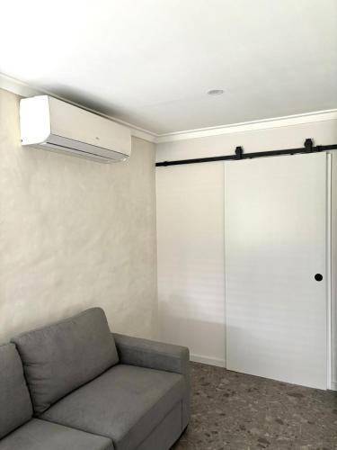 a living room with a couch and a sliding door at Versatile summer beach house or cosy winter retreat! in Mandurah
