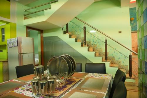 a dining room table with a mirror and a staircase at The HR STAY INN TIRUPATI - LUXURY HOMESTAY - NEAR ALIPIRI BUS STAND AND KAPILATEERTHAM - 24 HRS HOT WATER-150 MBPS SPEED FREE WIFI & ALL OTT APPS in Tirupati