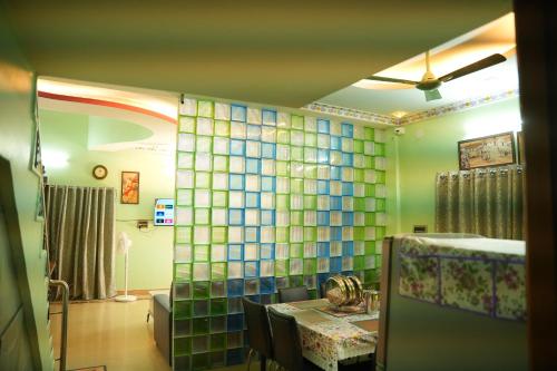 a dining room with a table and a glass wall at The HR STAY INN TIRUPATI - LUXURY HOMESTAY - NEAR ALIPIRI BUS STAND AND KAPILATEERTHAM - 24 HRS HOT WATER-150 MBPS SPEED FREE WIFI & ALL OTT APPS in Tirupati