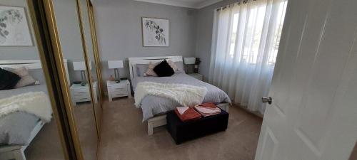 ブロークンヒルにあるMcGowen st accommodationのベッドと鏡のある白い寝室